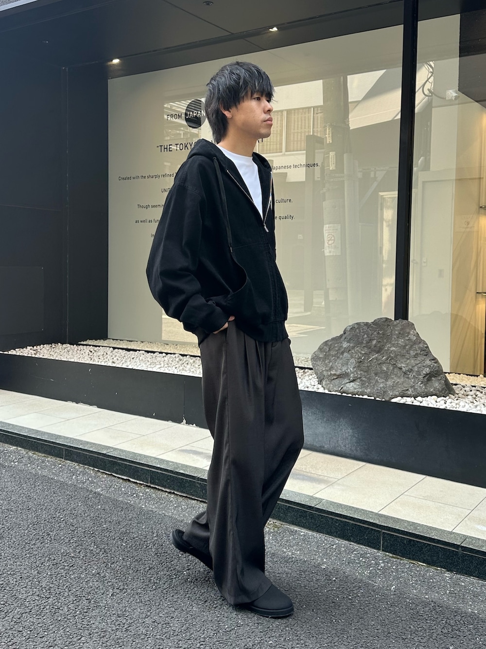 ブラック系のブルゾン、グレー系のスラックス、ブラック系のサンダルを着用したメンズの秋コーディネートの4枚目の写真