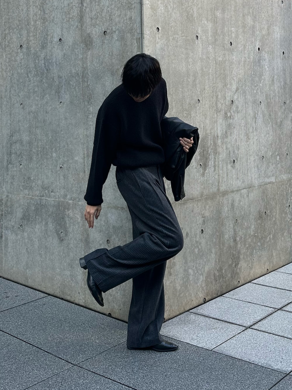 ブラック系のニット/セーター、ブラック系のブルゾン、ブラック系のスラックスを着用したメンズの冬コーディネートの5枚目の写真