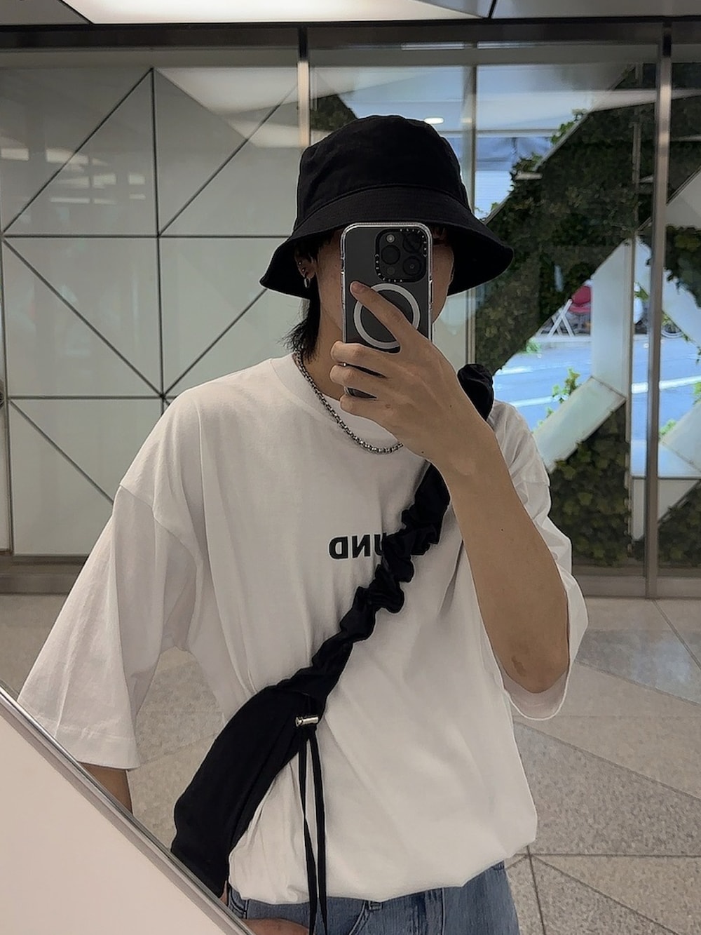 ブラック系のショルダーバッグ、ホワイト系のTシャツ/カットソー、ブルー系のパンツを着用したメンズの夏コーディネートの5枚目の写真