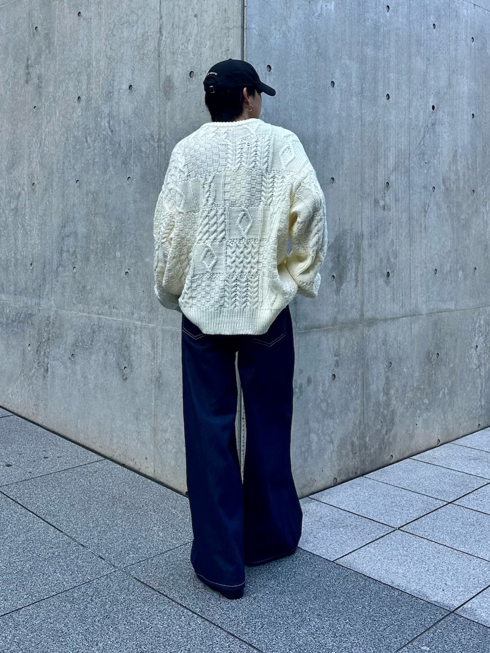 ホワイト系のニット/セーター、ブルー系のデニムパンツ、ブラック系のキャップを着用したメンズの秋コーディネートの3枚目の写真