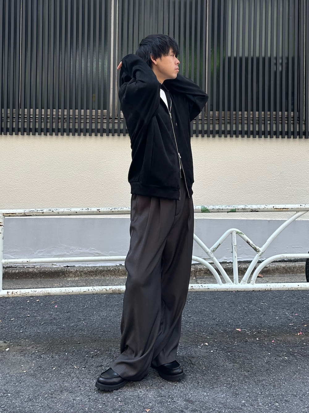 ブラック系のパーカー、グレー系のスラックス、ブラック系のドレスシューズを着用したメンズの夏コーディネートの2枚目の写真