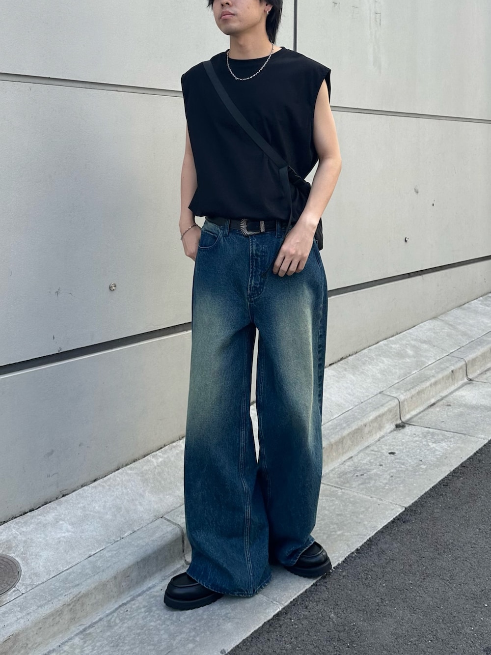 ブラック系のTシャツ/カットソー、ブラック系のショルダーバッグ、ブルー系のデニムパンツを着用したメンズの夏コーディネートの3枚目の写真