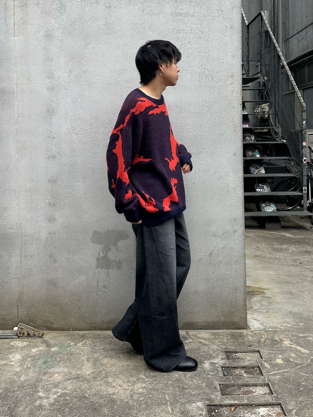 ブルー系のニット/セーター、ブラック系のデニムパンツ、ブラック系のブーツを着用したメンズの秋コーディネートの4枚目の写真