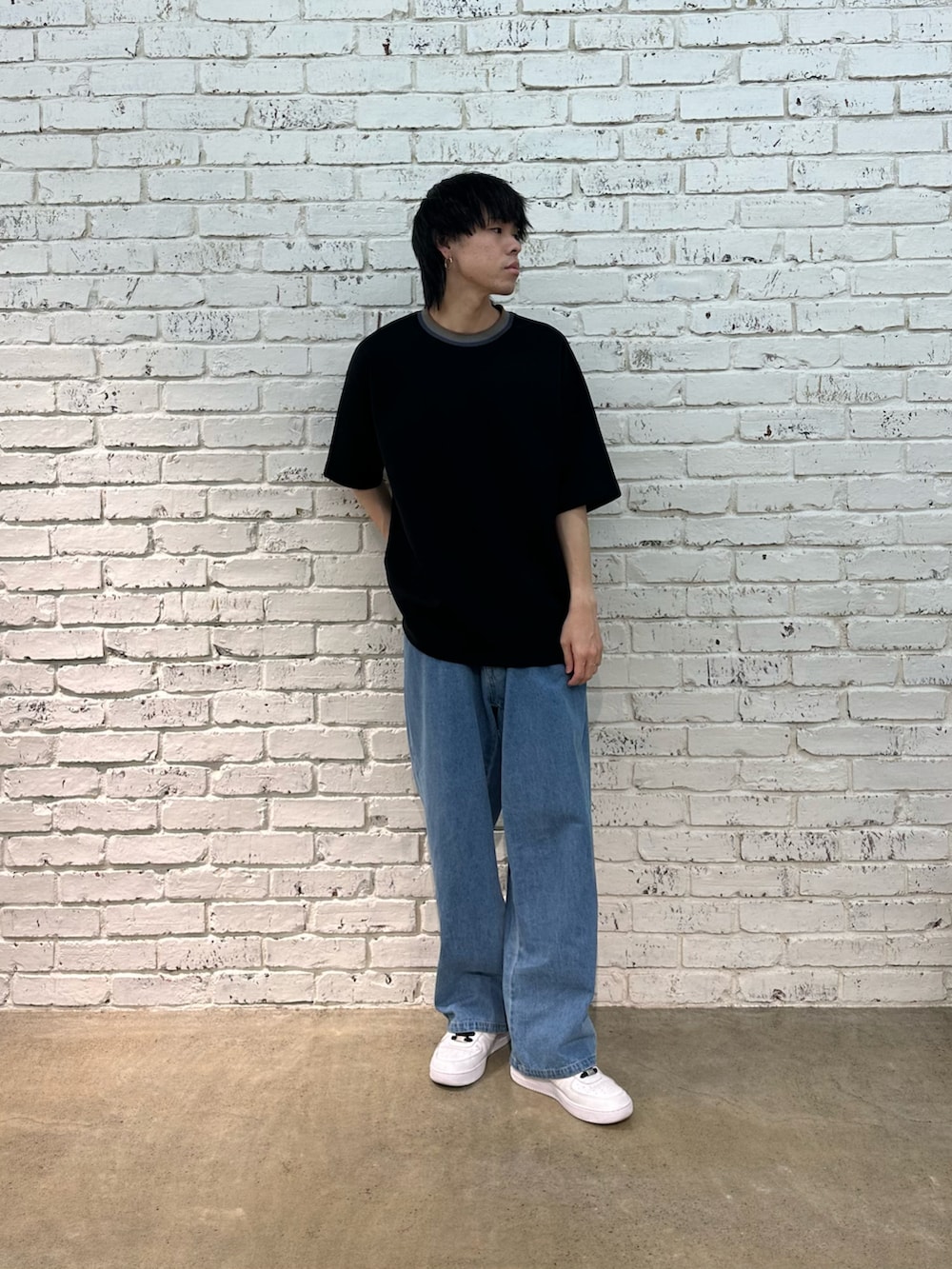 ブラック系のTシャツ/カットソー、ブルー系のデニムパンツを着用したメンズの春コーディネートの5枚目の写真