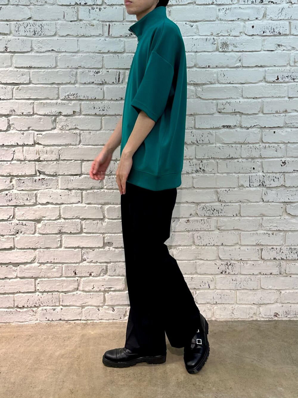 グリーン系のTシャツ/カットソー、ブラック系のスラックスを着用したメンズの春コーディネートの2枚目の写真