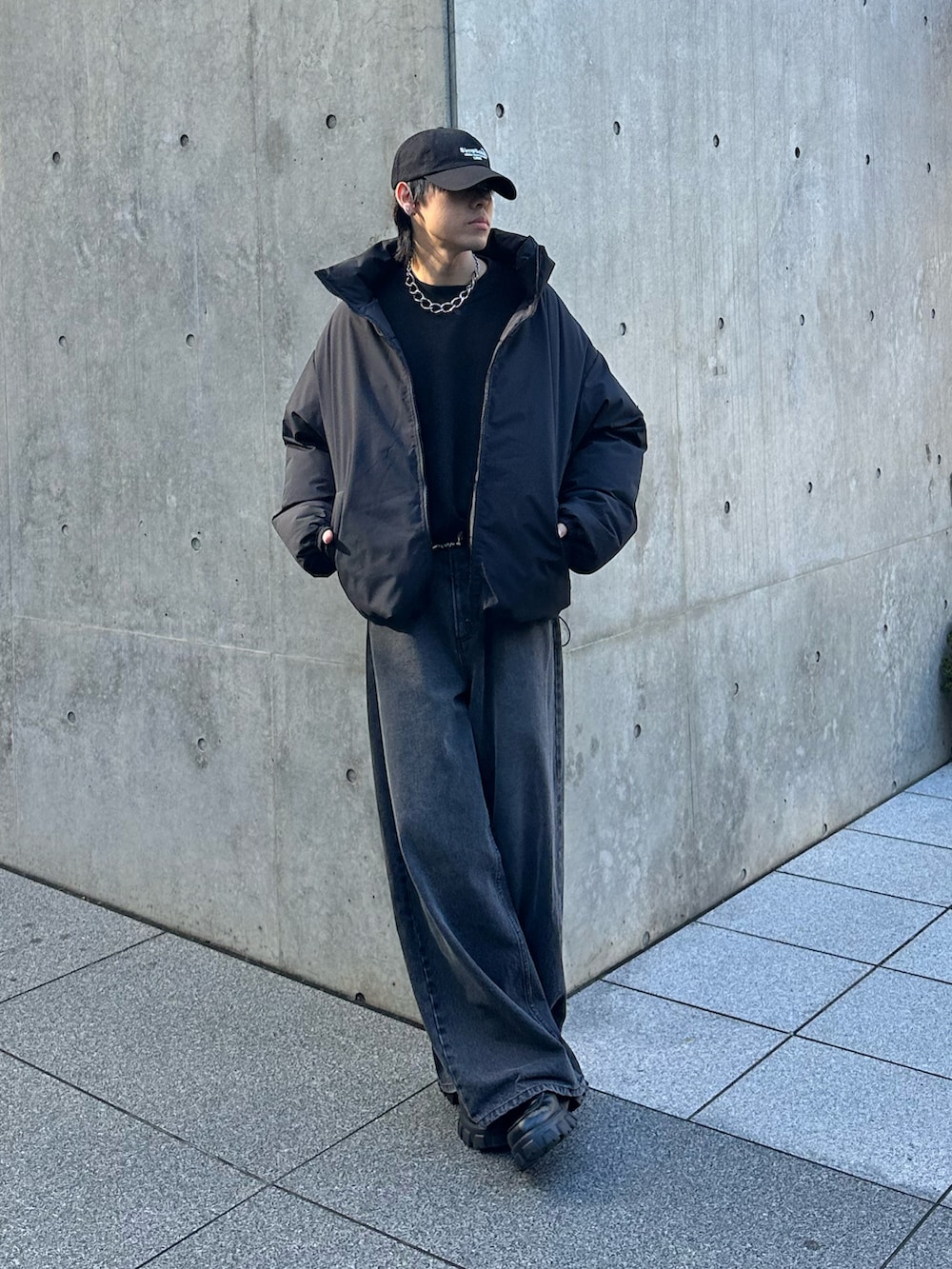 ブラック系のデニムパンツ、ブラック系のダウンジャケット/コート、ブラック系のキャップを着用したメンズの冬コーディネートの2枚目の写真