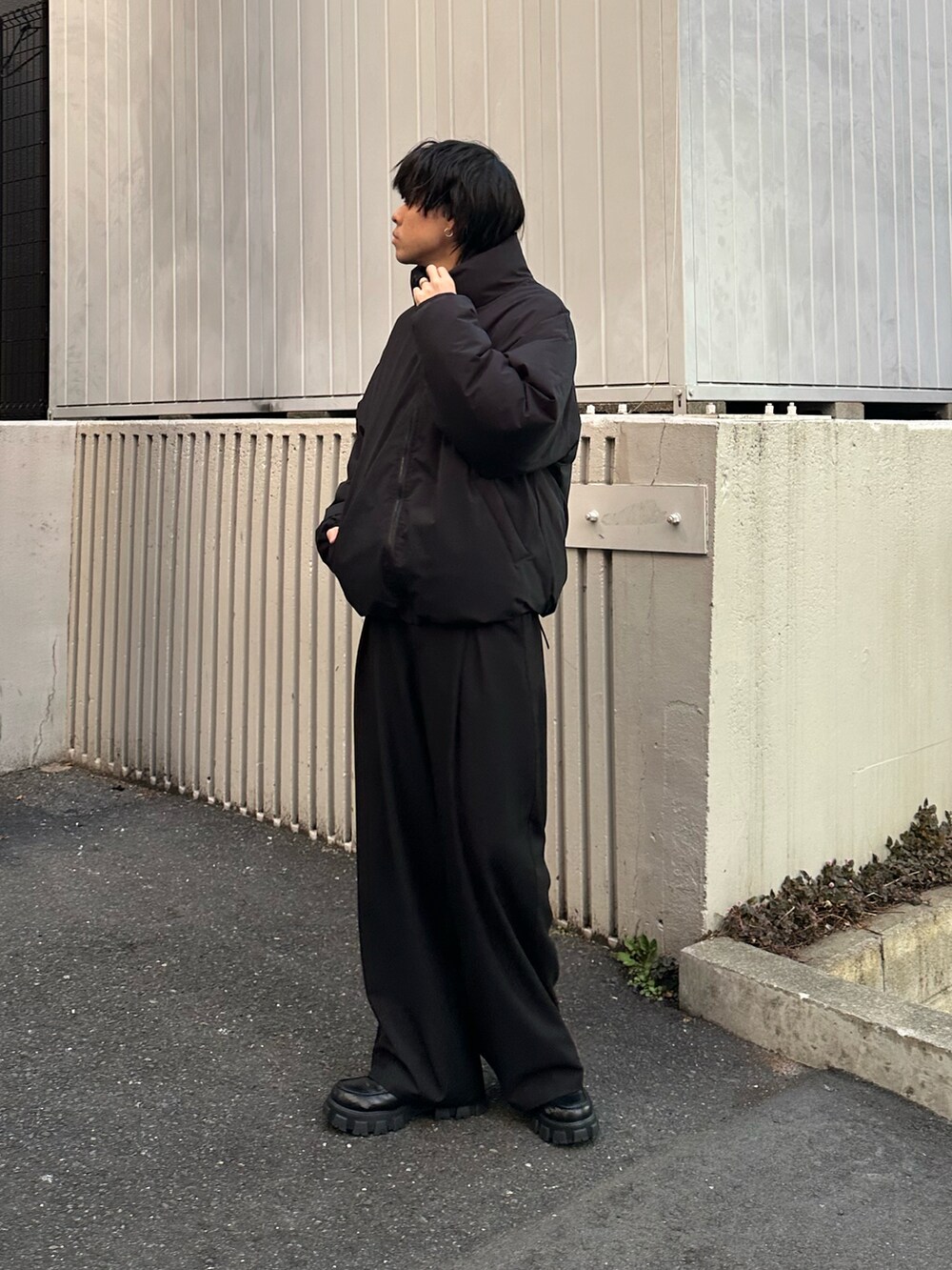 ブラック系のダウンジャケット/コート、ホワイト系のTシャツ/カットソー、ブラック系のスラックスを着用したメンズの冬コーディネートの3枚目の写真