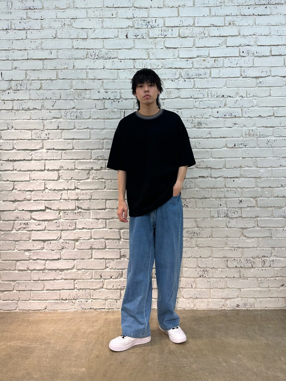 ブラック系のTシャツ/カットソー、ブルー系のデニムパンツを着用したメンズの春コーディネートの4枚目の写真