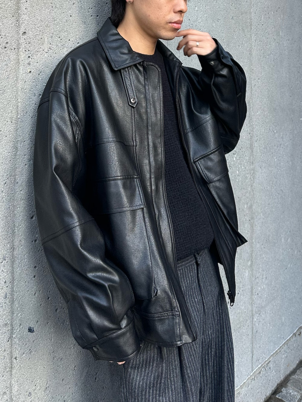 ブラック系のニット/セーター、ブラック系のブルゾン、ブラック系のスラックスを着用したメンズの冬コーディネートの3枚目の写真