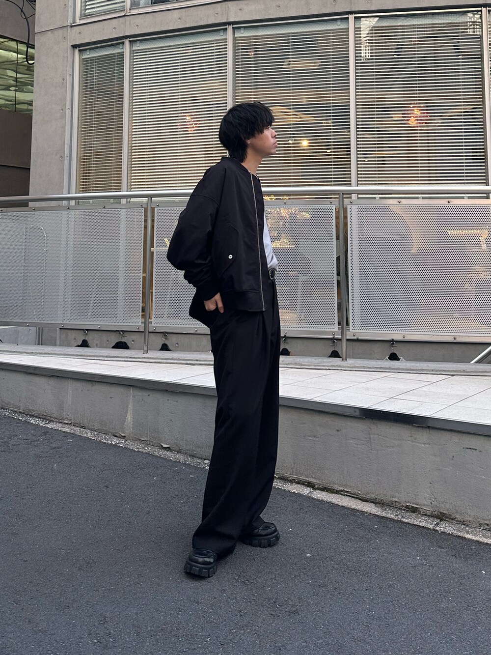 ブラック系のMA-1、グレー系のTシャツ/カットソー、ブラック系のスラックスを着用したメンズの冬コーディネートの3枚目の写真