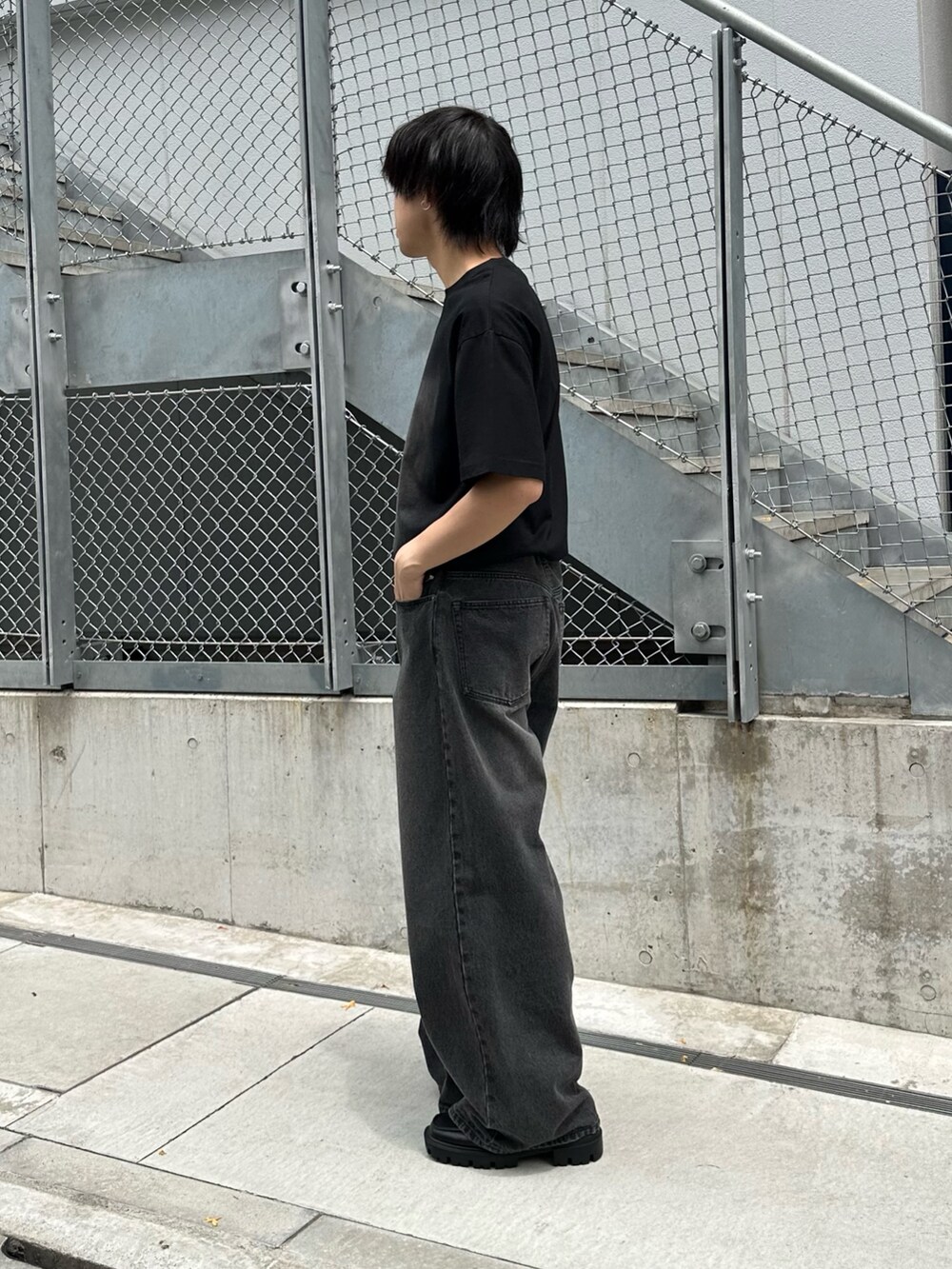 ブラック系のTシャツ/カットソー、ブラック系のデニムパンツ、ブラック系のベルトを着用したメンズの春コーディネートの2枚目の写真