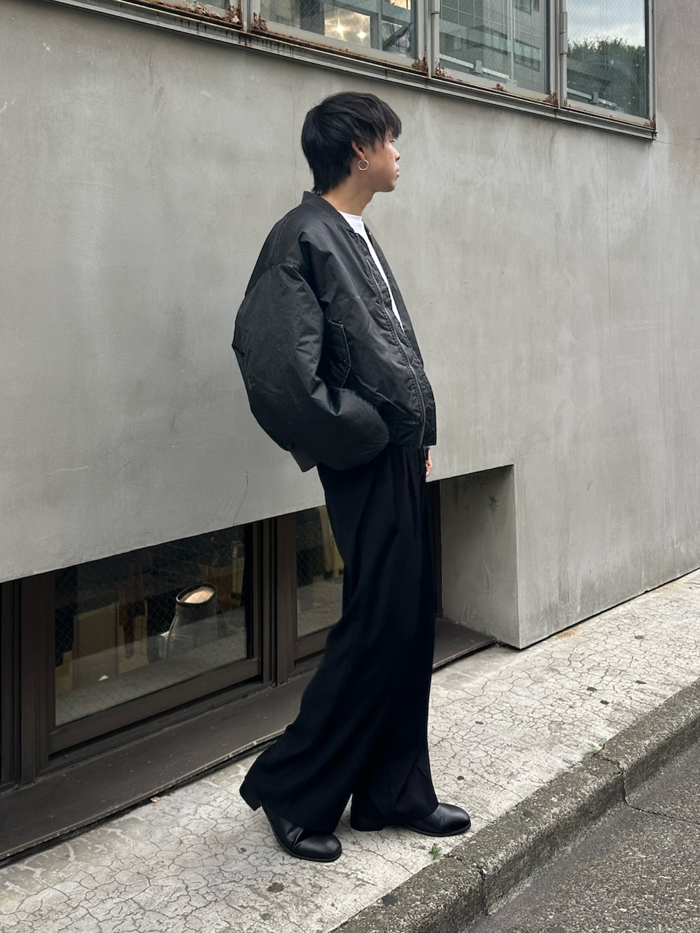 ブラック系のブルゾン、ブラック系のスラックス、ブラック系のベルトを着用したメンズの秋コーディネートの4枚目の写真