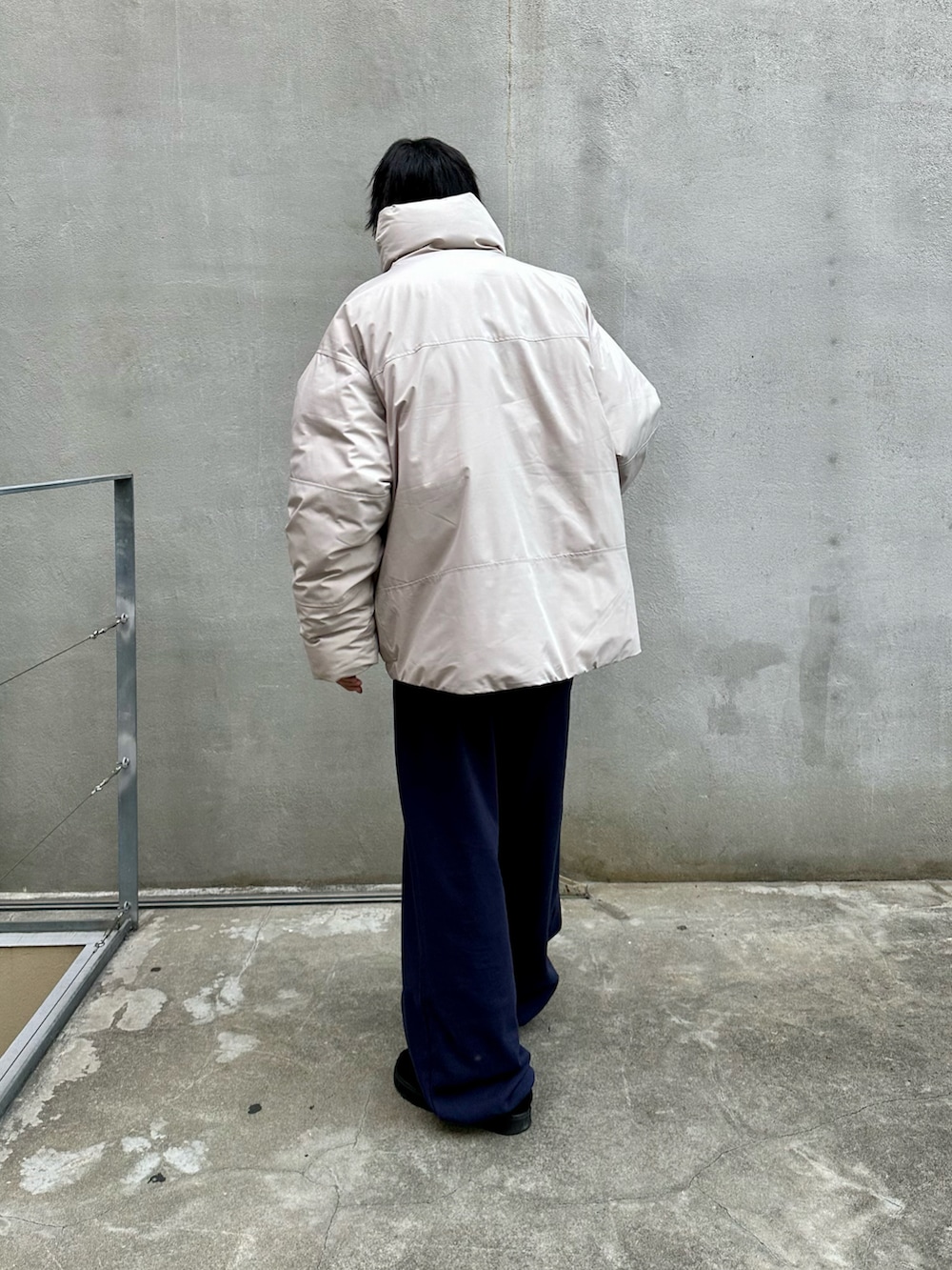 グレー系のダウンジャケット/コート、ブルー系のスウェットパンツ、ブラック系のモカシン/デッキシューズを着用したメンズの秋コーディネートの3枚目の写真