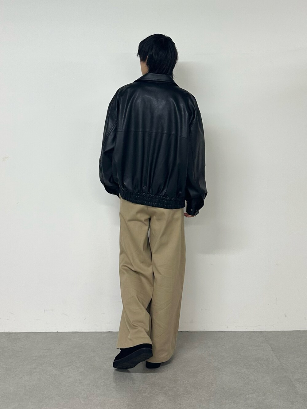 ブラック系のブルゾン、ベージュ系のその他パンツを着用したメンズの秋コーディネートの3枚目の写真