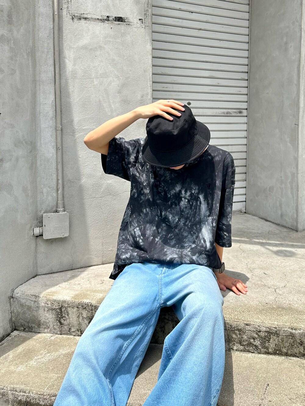 ブラック系のTシャツ/カットソー、ブラック系のメッセンジャーバッグ、ブルー系のデニムパンツを着用したメンズの夏コーディネートの2枚目の写真