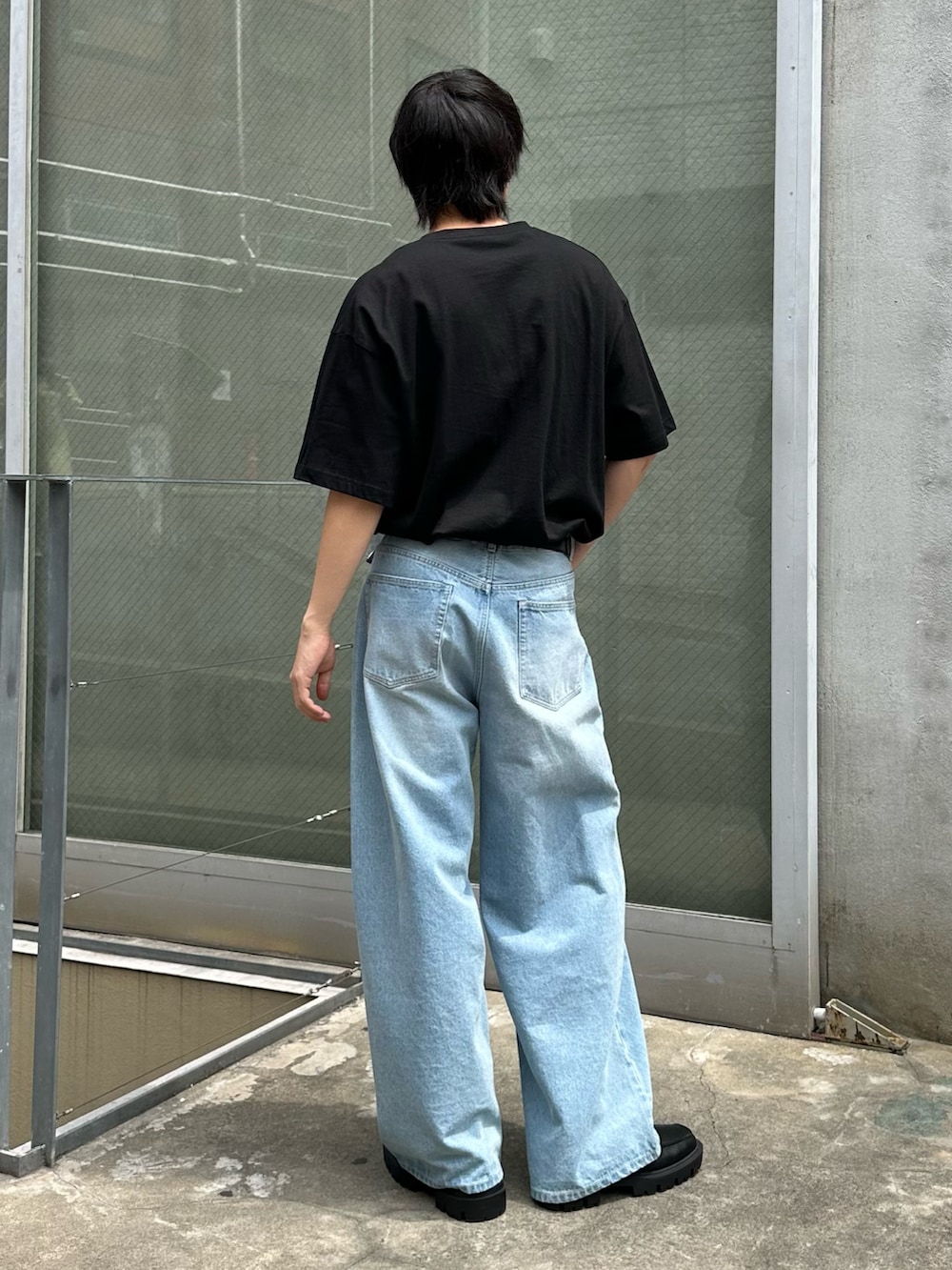 ホワイト系のTシャツ/カットソー、ブルー系のデニムパンツ、ブラック系のベルトを着用したメンズの春コーディネートの3枚目の写真