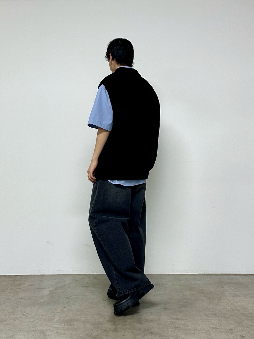 ブラック系のベスト、ブルー系のシャツ/ブラウス、ブラック系のデニムパンツを着用したメンズの春コーディネートの3枚目の写真