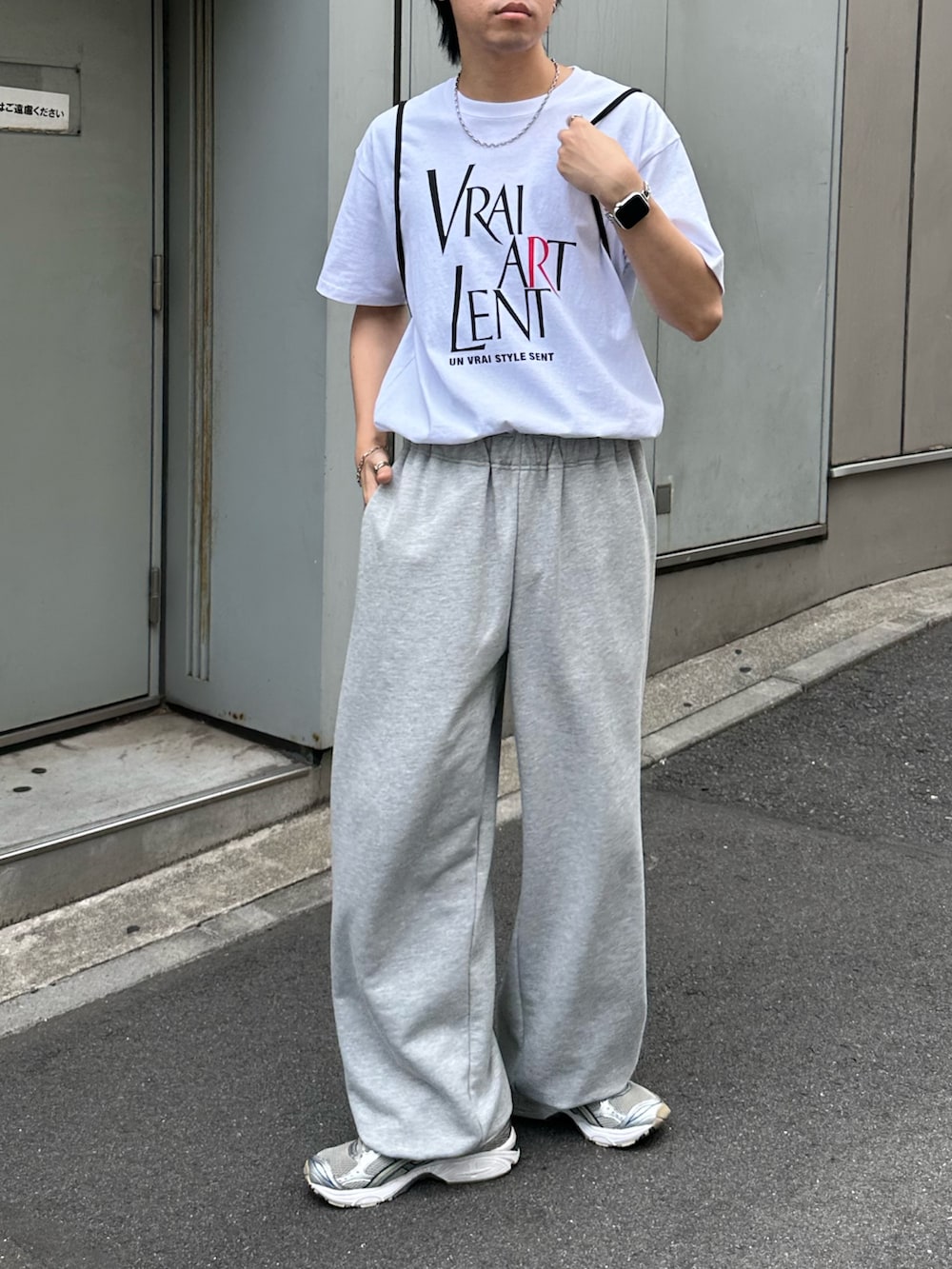 ブラック系のバックパック/リュック、グレー系のスウェットパンツ、ホワイト系のTシャツ/カットソーを着用したメンズの夏コーディネートの3枚目の写真