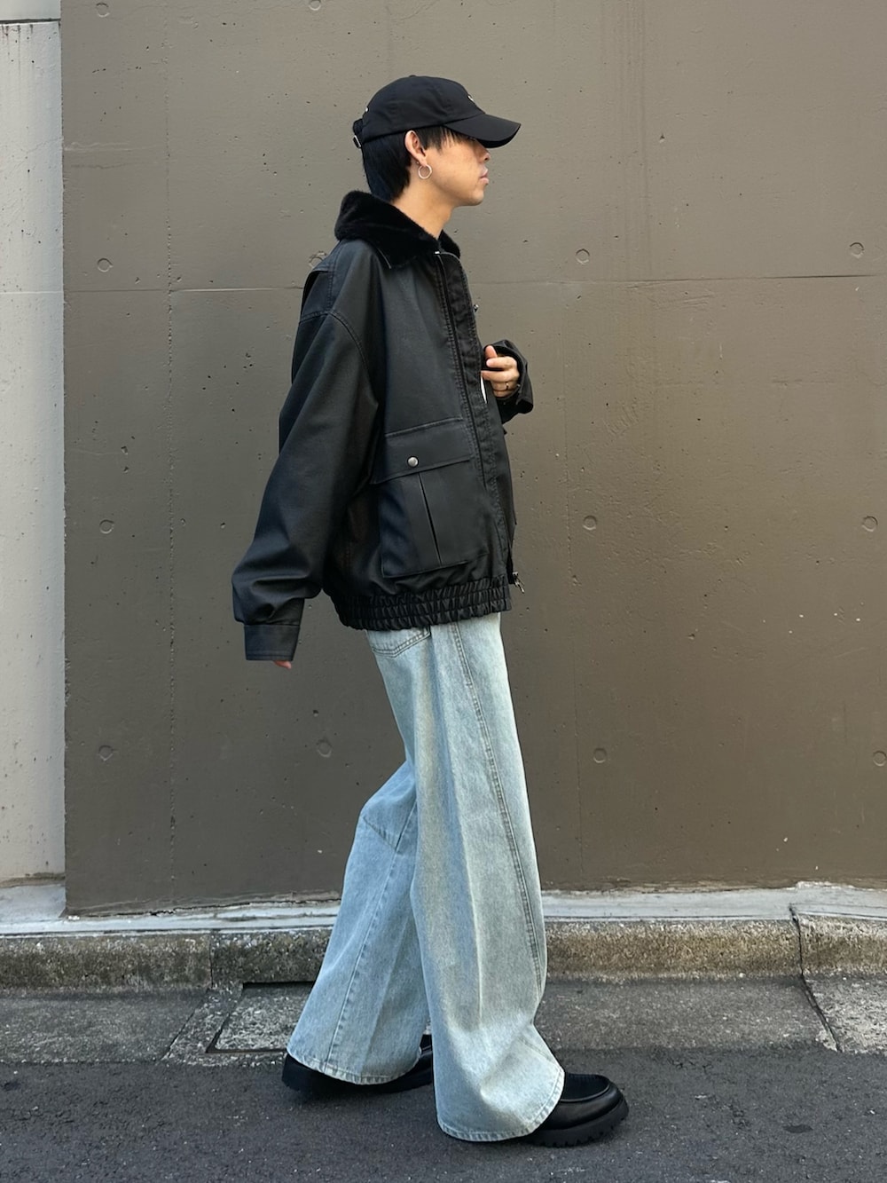 ブルー系のデニムパンツ、ブラック系のドレスシューズ、ブラック系のブルゾンを着用したメンズの秋コーディネートの4枚目の写真