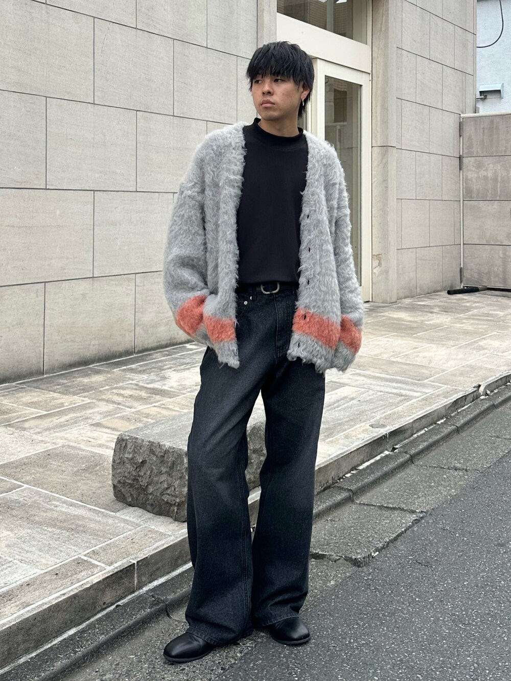 ブラック系のカーディガン/ボレロ、ブラック系のTシャツ/カットソー、ブラック系のデニムパンツを着用したメンズの秋コーディネートの5枚目の写真