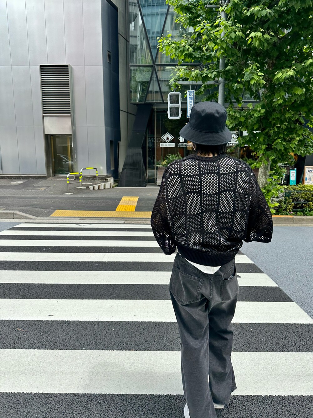 ブラック系のニット/セーター、ブラック系のデニムパンツ、ホワイト系のタンクトップを着用したメンズの夏コーディネートの5枚目の写真