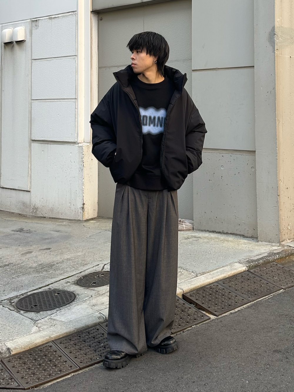 ブラック系のダウンジャケット/コート、グレー系のスラックスを着用したメンズの冬コーディネートの5枚目の写真