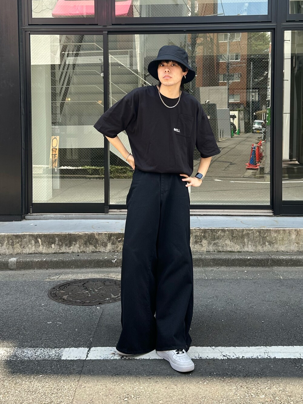 ブラック系のデニムパンツ、ホワイト系のスニーカー、ブラック系のTシャツ/カットソーを着用したメンズの夏コーディネートの3枚目の写真