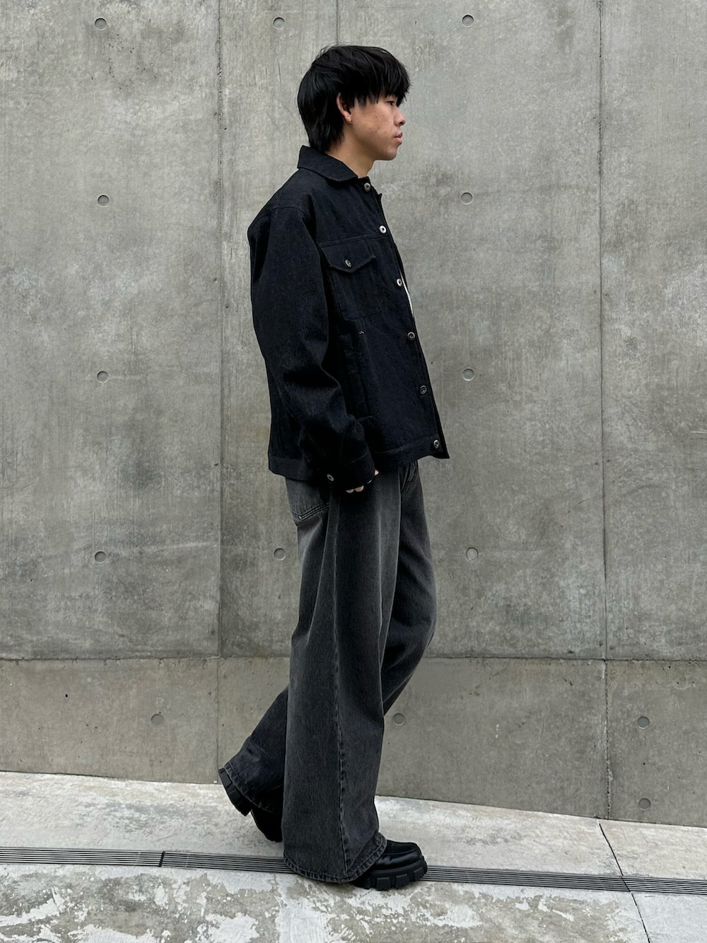 ブラック系のデニムジャケット、グレー系のTシャツ/カットソー、ブラック系のデニムパンツを着用したメンズの冬コーディネートの4枚目の写真