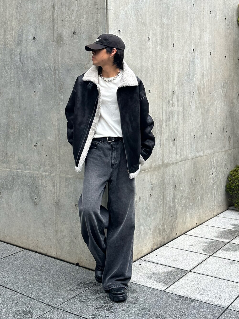 ブラック系のデニムパンツ、ブラック系のムートンコート、ブラック系のキャップを着用したメンズの秋コーディネートの4枚目の写真