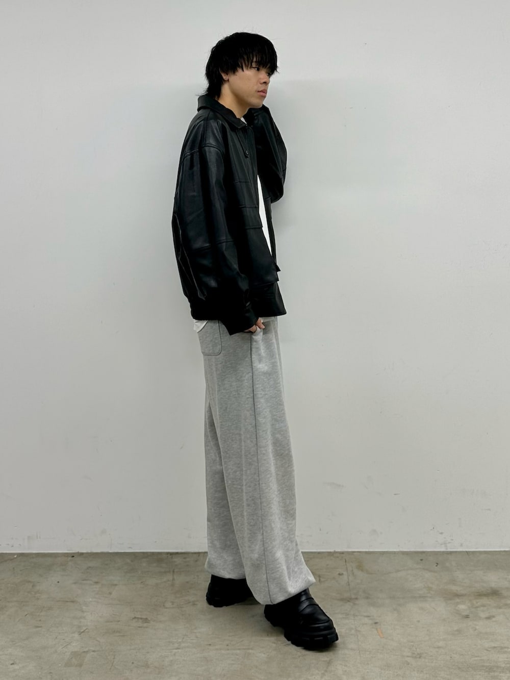 ブラック系のブルゾン、ホワイト系のTシャツ/カットソー、グレー系のスウェットパンツを着用したメンズの秋コーディネートの4枚目の写真