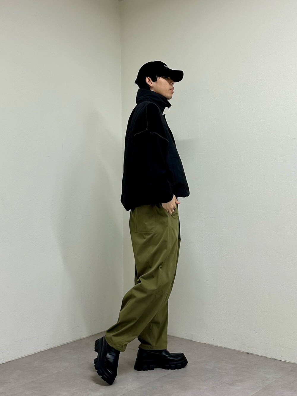 ブラック系のベスト、グリーン系のその他パンツ、ブラック系のスウェットを着用したメンズの春コーディネートの3枚目の写真