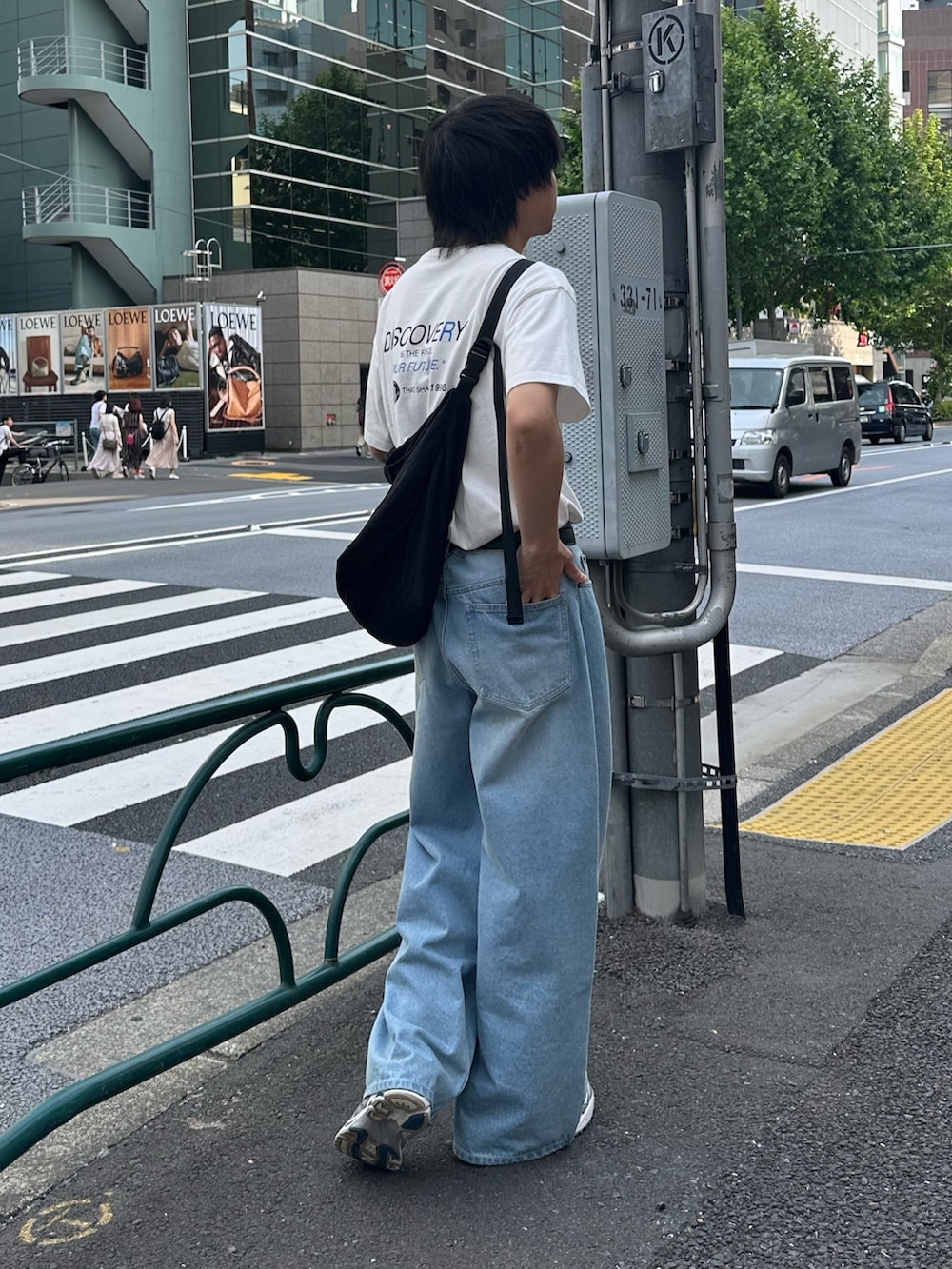 ホワイト系のTシャツ/カットソー、ブラック系のショルダーバッグ、ブルー系のデニムパンツを着用したメンズの春コーディネートの2枚目の写真