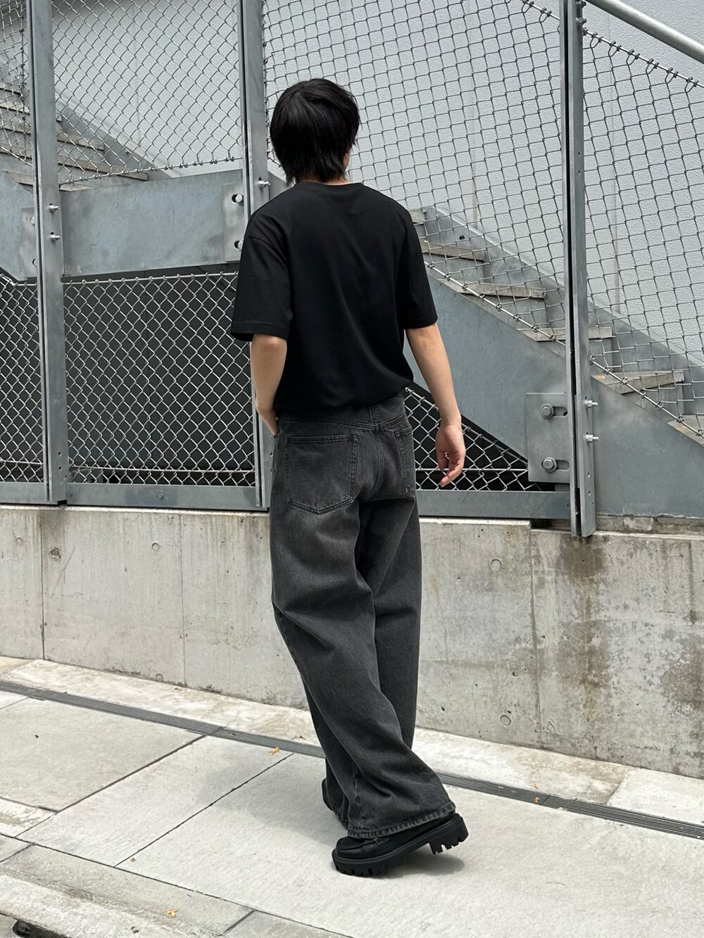 ブラック系のTシャツ/カットソー、ブラック系のデニムパンツ、ブラック系のベルトを着用したメンズの春コーディネートの3枚目の写真