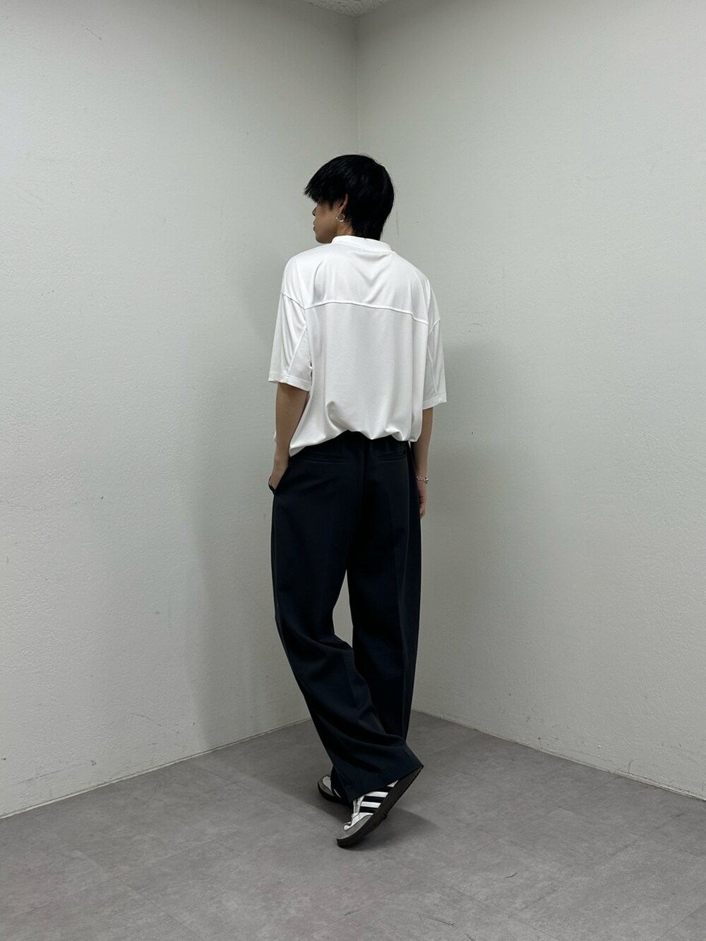 ホワイト系のTシャツ/カットソー、ブラック系のスラックスを着用したメンズの春コーディネートの3枚目の写真