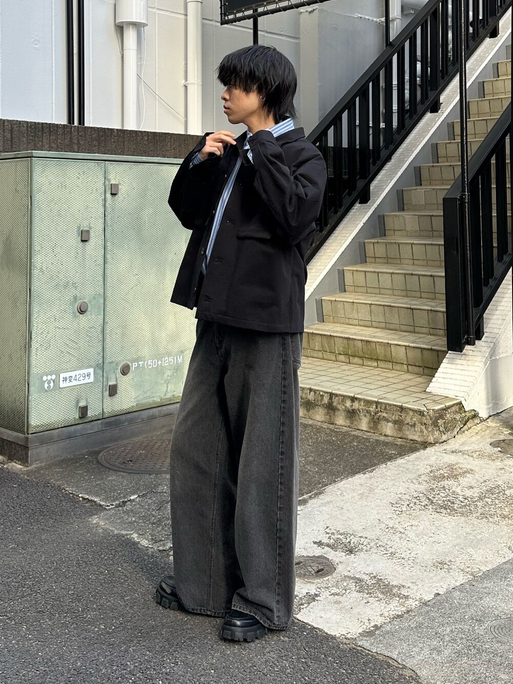 ブラック系のその他アウター、ブラック系のデニムパンツ、ブラック系のベルトを着用したメンズの冬コーディネートの2枚目の写真