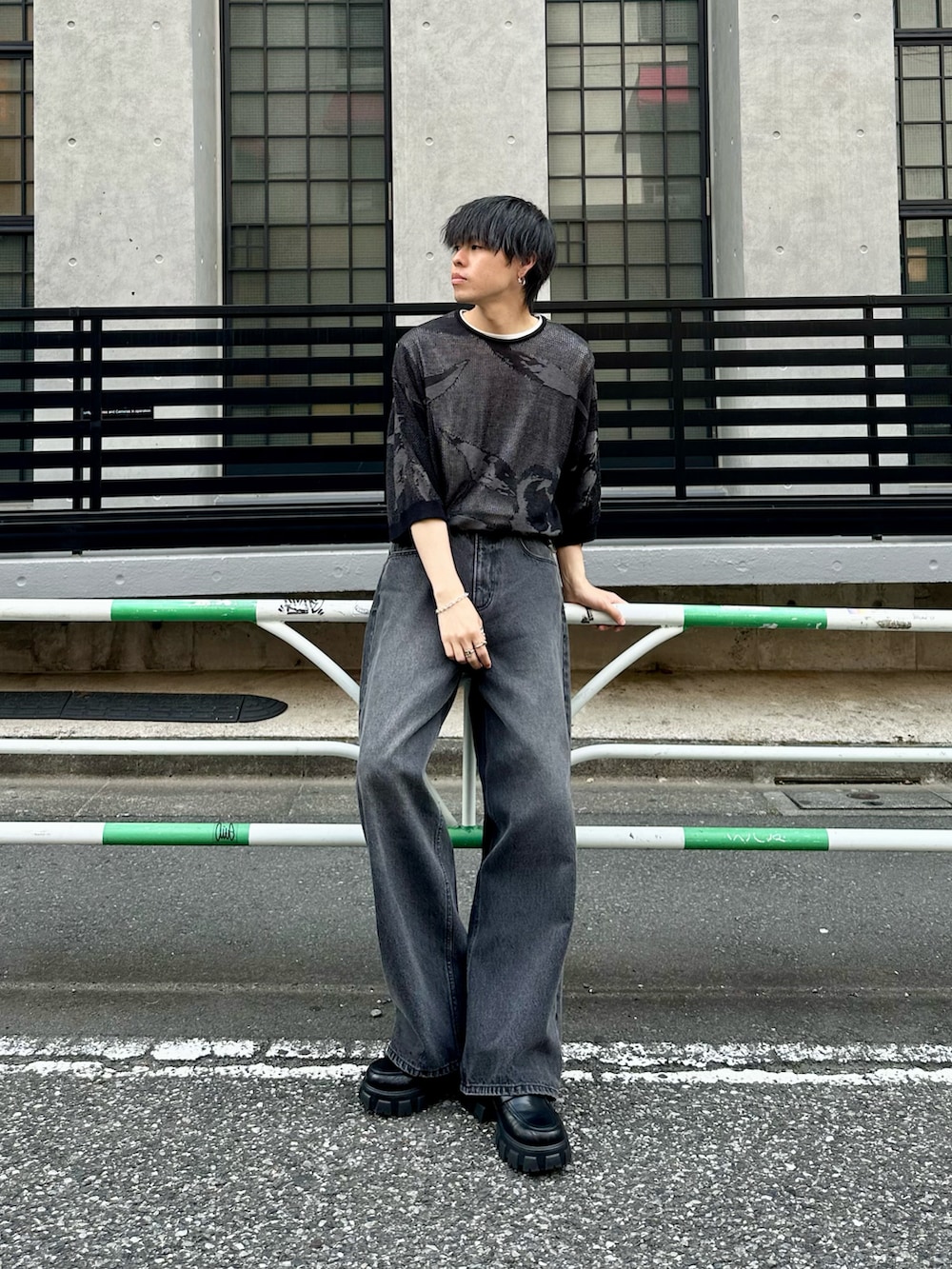 ブラック系のニット/セーター、ホワイト系のTシャツ/カットソー、ブラック系のデニムパンツを着用したメンズの夏コーディネートの2枚目の写真