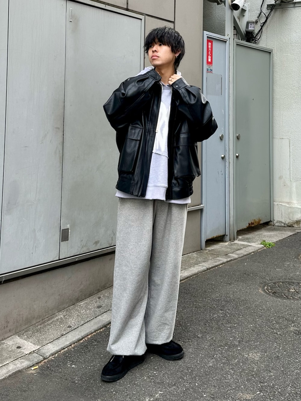 ブラック系のブルゾン、グレー系のパーカー、グレー系のスウェットパンツを着用したメンズの冬コーディネートの4枚目の写真