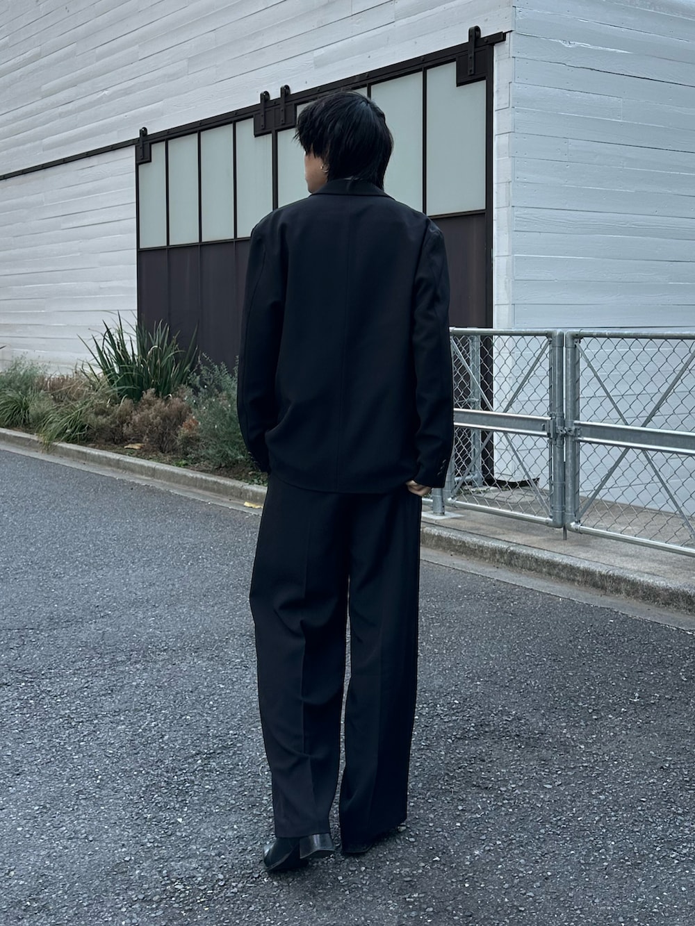 ブラック系のテーラードジャケット、ブラック系のスラックス、ブラック系のベルトを着用したメンズの冬コーディネートの3枚目の写真