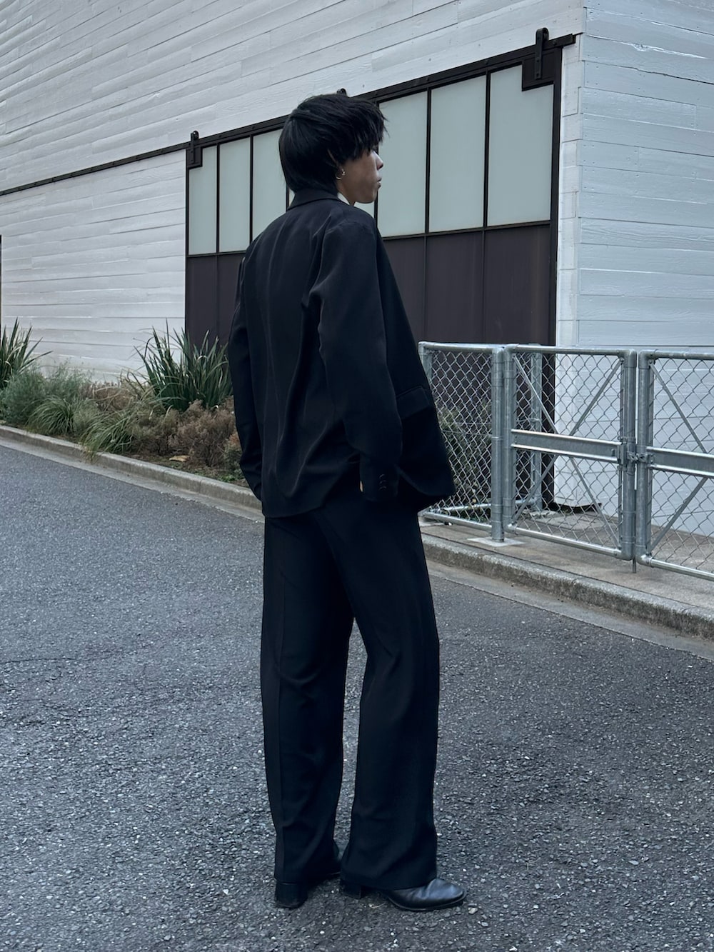 ブラック系のテーラードジャケット、ブラック系のスラックス、ブラック系のベルトを着用したメンズの冬コーディネートの4枚目の写真