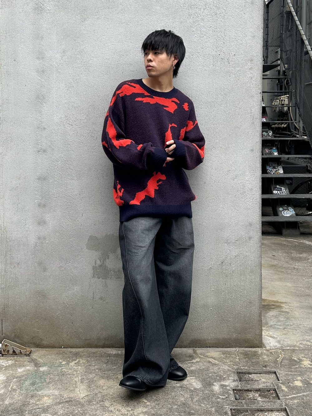 ブルー系のニット/セーター、ブラック系のデニムパンツ、ブラック系のブーツを着用したメンズの秋コーディネートの5枚目の写真