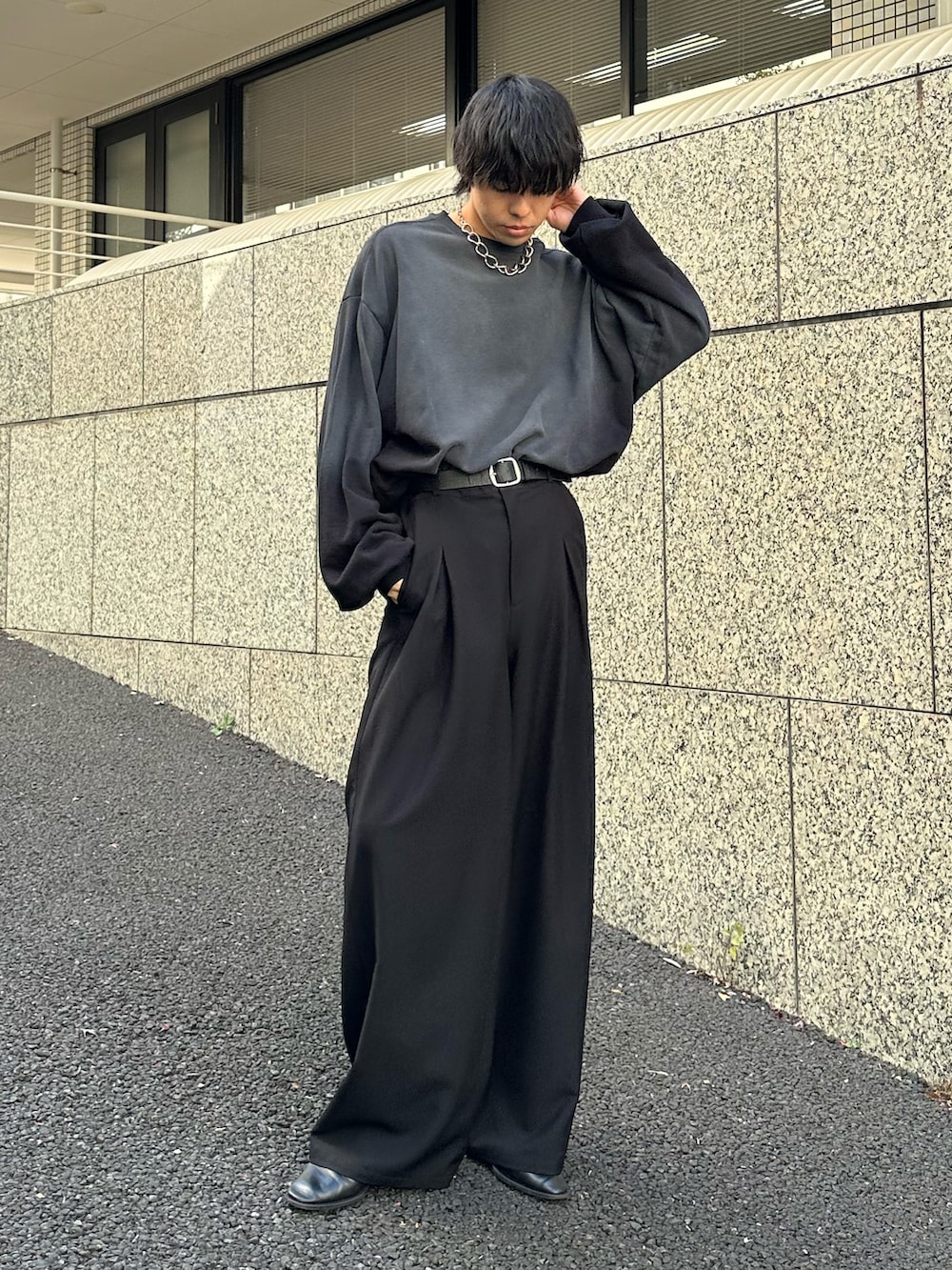 ブラック系のスラックス、ブラック系のベルトを着用したメンズの春コーディネートの3枚目の写真