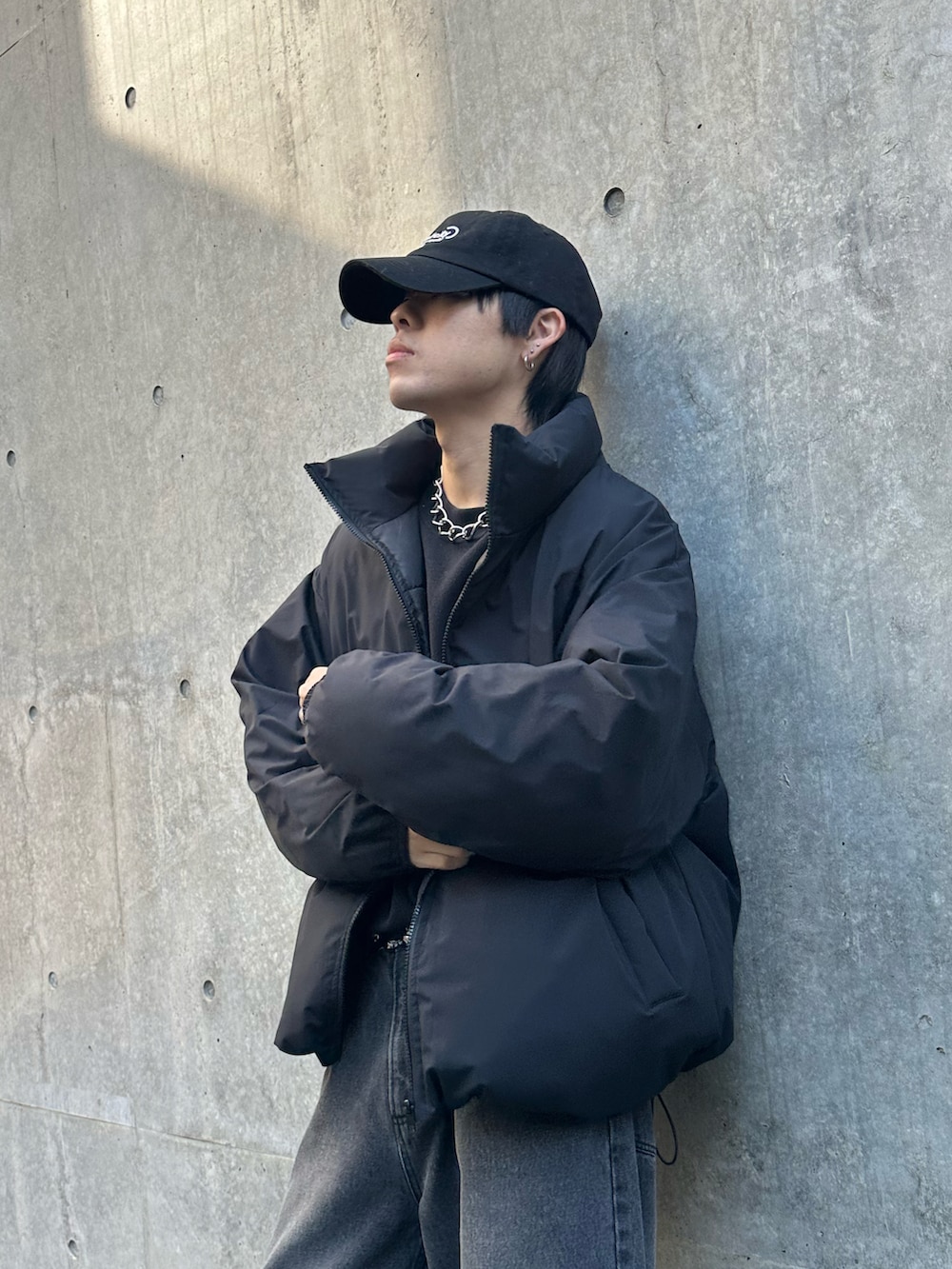 ブラック系のデニムパンツ、ブラック系のダウンジャケット/コート、ブラック系のキャップを着用したメンズの冬コーディネートの5枚目の写真