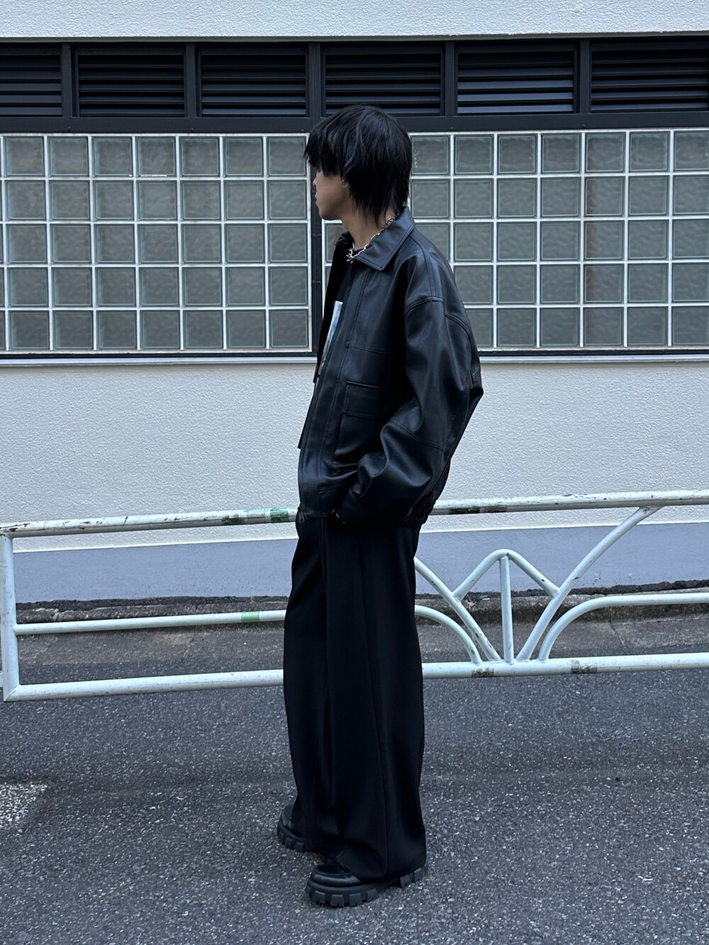 ブラック系のブルゾン、ブラック系のTシャツ/カットソー、ブラック系のスラックスを着用したメンズの冬コーディネートの5枚目の写真