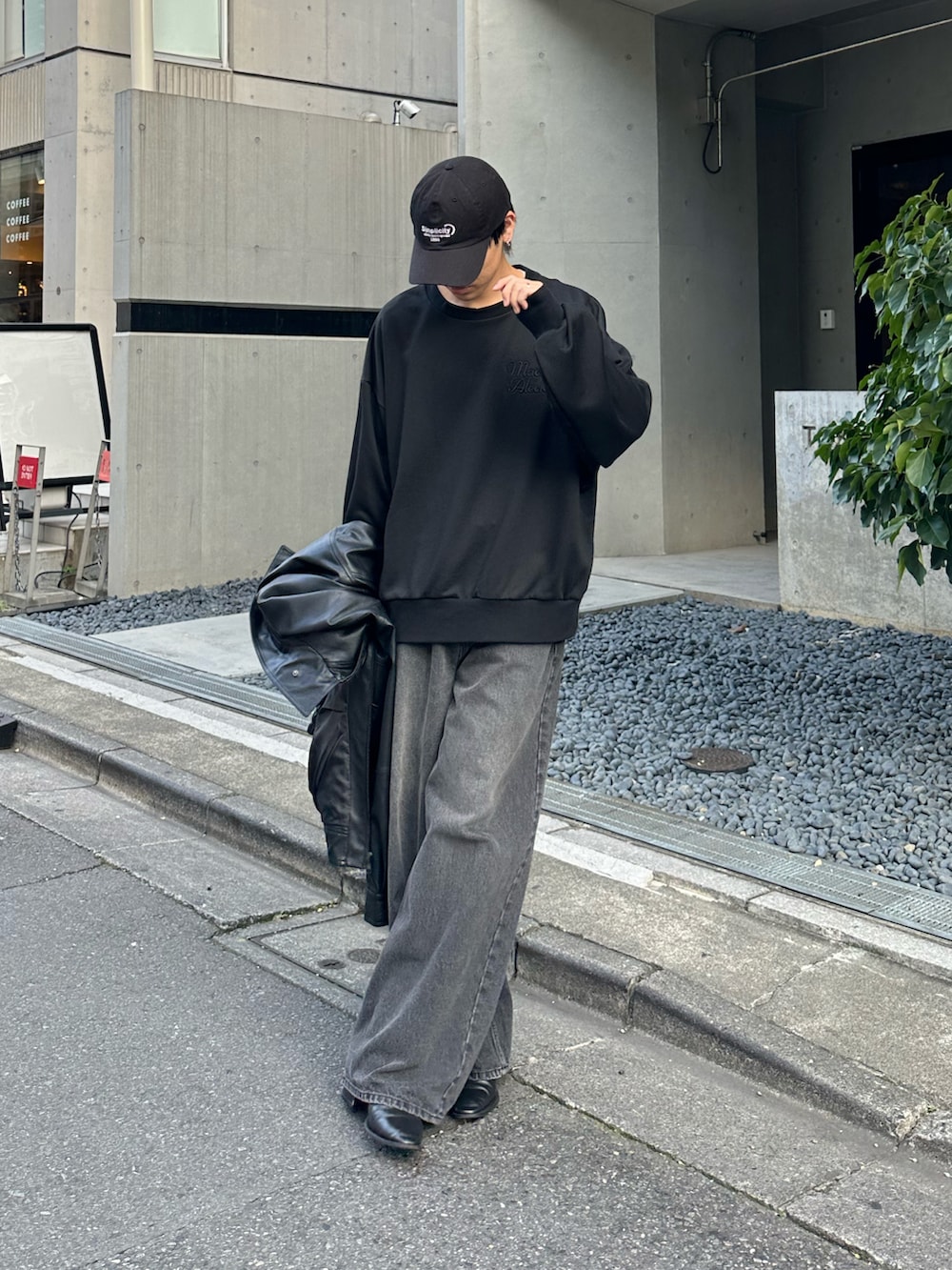 ブラック系のTシャツ/カットソー、ブラック系のデニムパンツ、ブラック系のブルゾンを着用したメンズの秋コーディネートの3枚目の写真