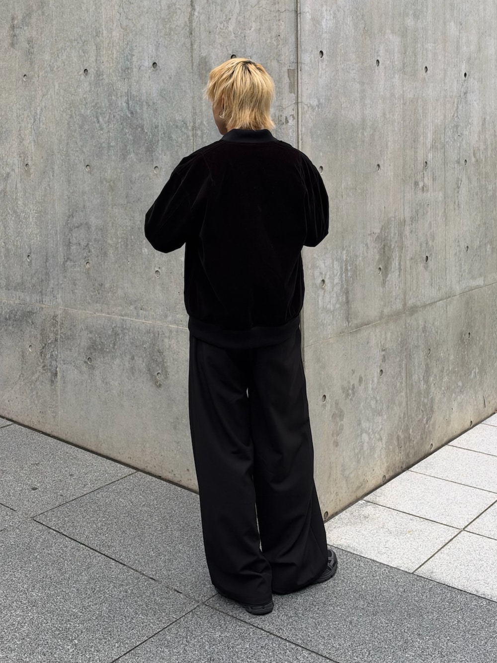 ブラック系のブルゾン、ブラック系のスラックス、ホワイト系のTシャツ/カットソーを着用したメンズの秋コーディネートの3枚目の写真