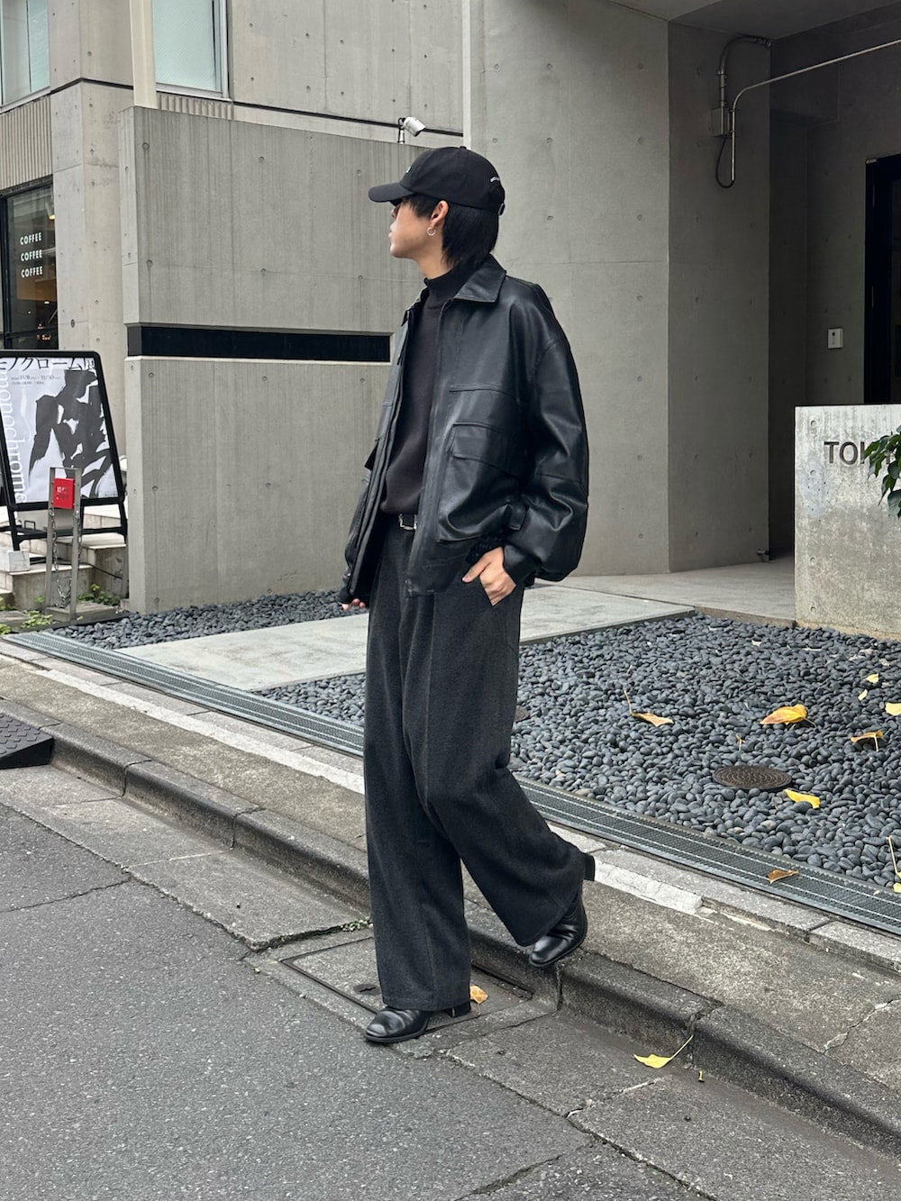 グレー系のスラックス、ブラック系のニット/セーター、ブラック系のブルゾンを着用したメンズの秋コーディネートの3枚目の写真