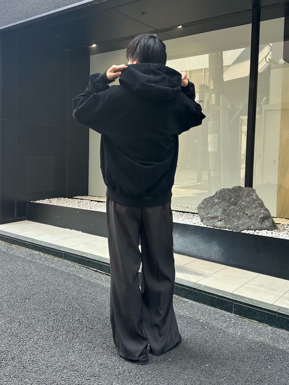 ブラック系のブルゾン、グレー系のスラックス、ブラック系のサンダルを着用したメンズの秋コーディネートの3枚目の写真