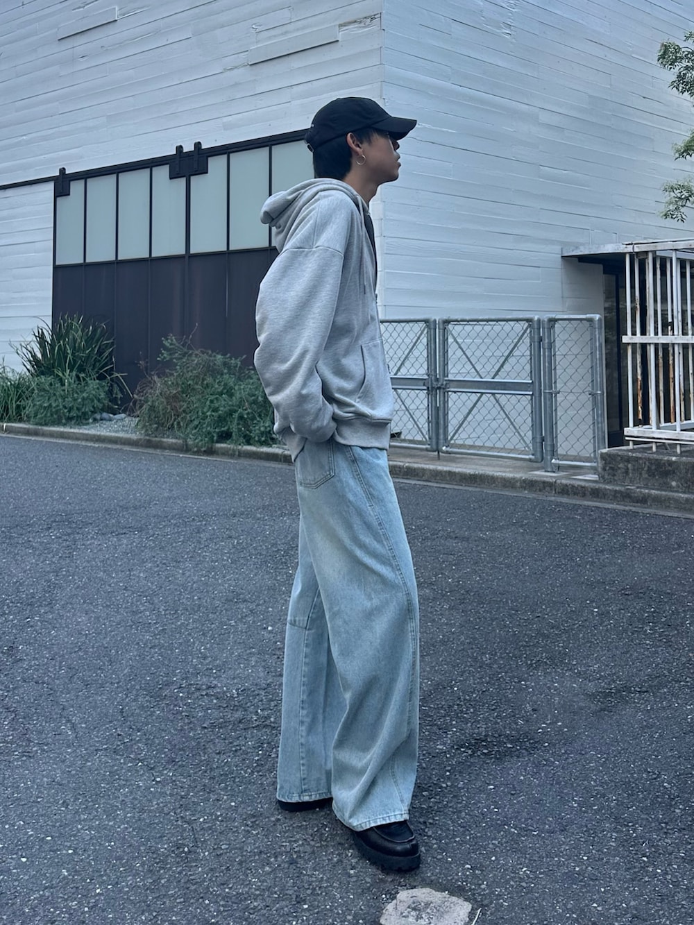 ブラック系のバックパック/リュック、グレー系のパーカー、ブルー系のデニムパンツを着用したメンズの秋コーディネートの4枚目の写真