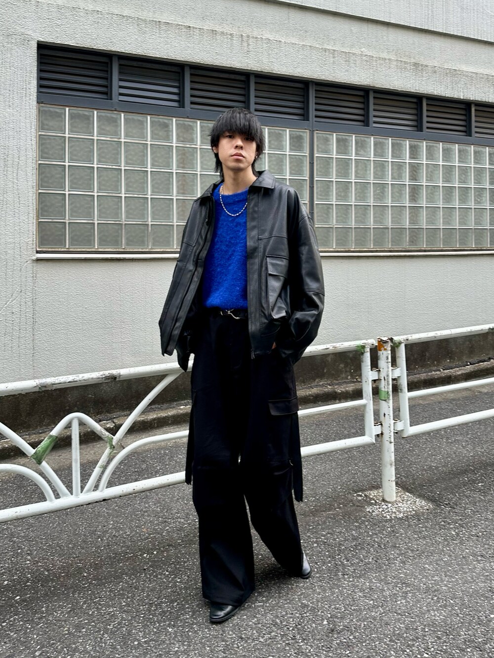 ブラック系のブルゾン、ブルー系のニット/セーター、ブラック系のカーゴパンツを着用したメンズの秋コーディネートの3枚目の写真