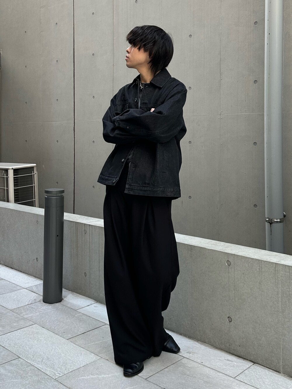 ブラック系のTシャツ/カットソー、ブラック系のスラックス、ブラック系のデニムジャケットを着用したメンズの春コーディネートの5枚目の写真